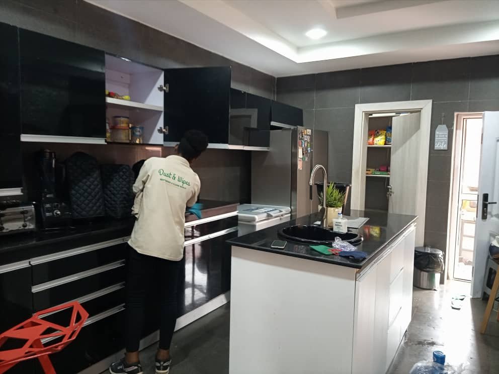 Dust and Wipes staff in green uniform cleaning commercial office in Abuja